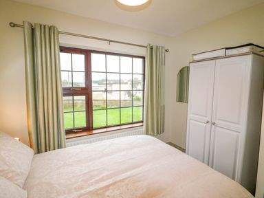 A bedroom with a window and wardrobe at Shamrock House