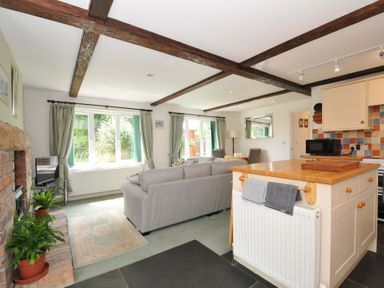 A living room featuring a sofa and television at Upper Court Cottage in Broad Langdon near Wainhouse Corner