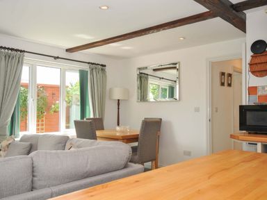 A living room with a sofa and dining table at Upper Court Cottage Broad Langdon near Wainhouse Corner