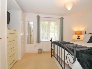 A bedroom with a bed and dresser at Upper Court Cottage in Broad Langdon near Wainhouse Corner