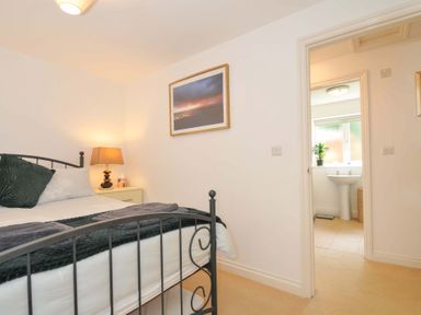 A bedroom with a bed and adjacent bathroom at Upper Court Cottage in Broad Langdon near Wainhouse Corner