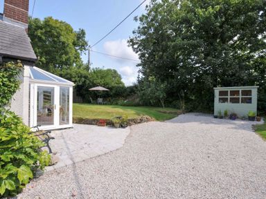 A garden with a conservatory and a shed at Upper Court Cottage in Broad Langdon near Wainhouse Corner