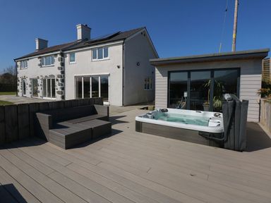 An outdoor area with a hot tub and seating at Criw in Bryncroes near Sarn Meyllteyrn