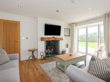 A living room with a fireplace and television at Criw near Sarn Meyllteyrn