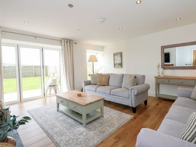 A living room with a sofa and coffee table at Criw in Bryncroes near Sarn Meyllteyrn