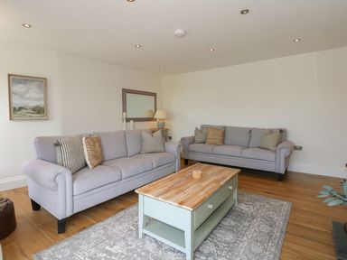 A living room with two sofas and a coffee table at Criw in Bryncroes near Sarn Meyllteyrn