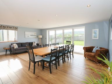 A dining room with a table and chairs at Criw in Bryncroes near Sarn Meyllteyrn