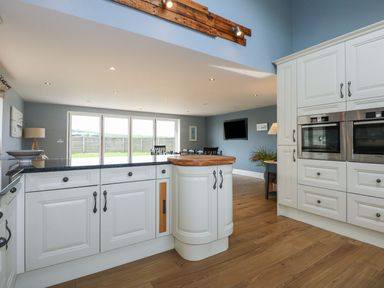 A kitchen with cabinets and a kitchen island at Criw, Bryncroes near Sarn Meyllteyrn