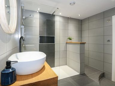 A bathroom with a shower and sink at Criw in Bryncroes near Sarn Meyllteyrn