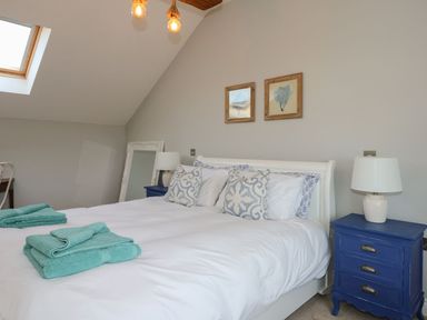 A bedroom with a bed and blue furniture at Criw in Bryncroes near Sarn Meyllteyrn