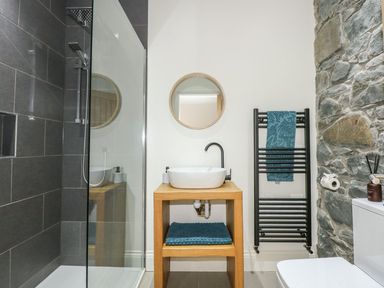 A bathroom with a shower and sink at Criw in Bryncroes near Sarn Meyllteyrn