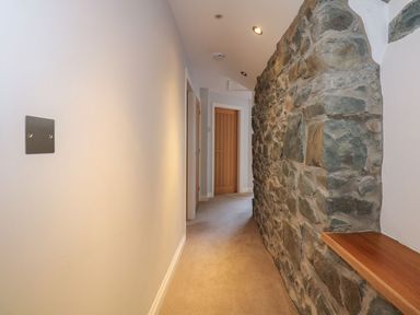 A hallway with a stone wall and doors at Criw in Bryncroes near Sarn Meyllteyrn
