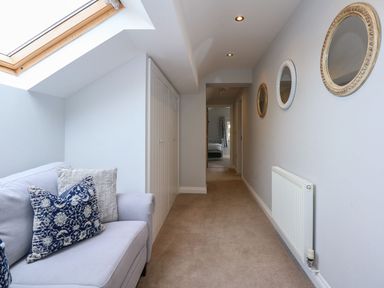 A hallway with a sofa and mirrors at Criw in Bryncroes near Sarn Meyllteyrn