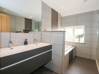 A bathroom with a sink and mirror at Criw in Bryncroes near Sarn Meyllteyrn