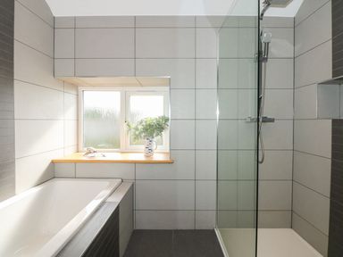 A bathroom with a bathtub and shower at Criw in Bryncroes near Sarn Meyllteyrn