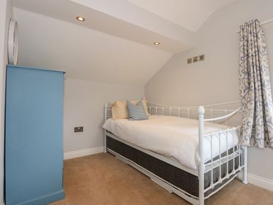 A bedroom with a bed and blue cabinet at Criw in Bryncroes near Sarn Meyllteyrn