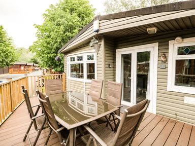 An outdoor patio with a table and chairs at Owls Nook Lodge, Langdale 9, White Cross Bay near Windermere