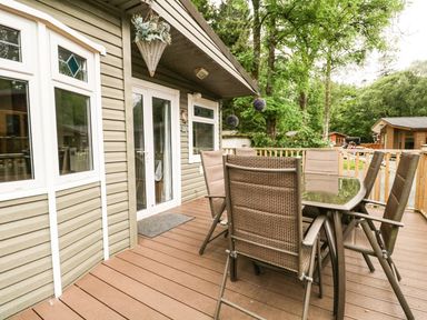 An outdoor seating area with a table and chairs at Owls Nook Lodge, Langdale 9, White Cross Bay near Windermere