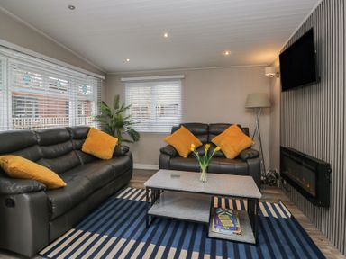 A living room with a sofa and coffee table at Owls Nook Lodge in Langdale 9, White Cross Bay near Windermere