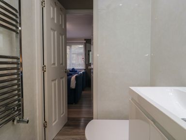 A bathroom with a sink and door to another room at Owls Nook Lodge in Langdale 9, White Cross Bay near Windermere