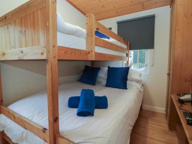 A bedroom with a bunk bed and a double bed at Owls Nook Lodge Langdale 9 White Cross Bay near Windermere