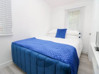 A bedroom with a bed covered in blue bedding at Jackos Lodge, Langdale 9, White Cross Bay near Windermere