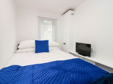 A bedroom with a bed and television at Jackos Lodge Langdale 9 White Cross Bay near Windermere