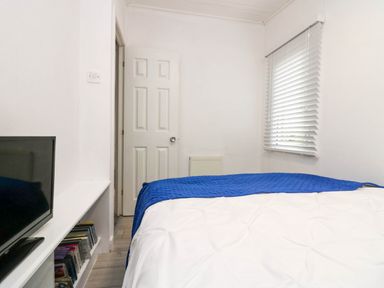 A bedroom with a bed and television at Jackos Lodge Langdale 9 White Cross Bay near Windermere