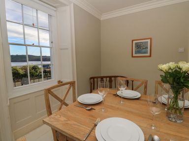 A dining room with a table set for a meal at Zenobia in New Quay