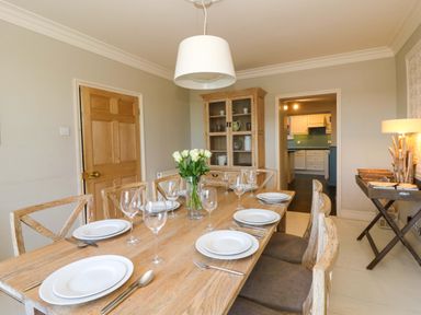 A dining room with a wooden table set at Zenobia New Quay