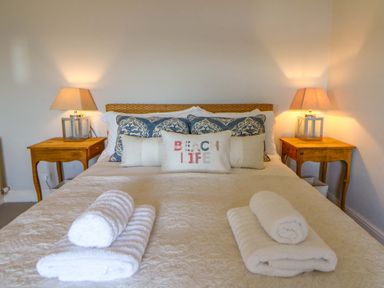 A bedroom with a bed and bedside tables at Zenobia in New Quay
