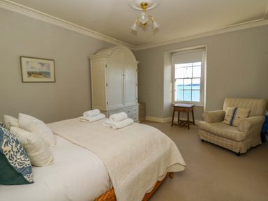 A bedroom with a bed and wardrobe at Zenobia in New Quay