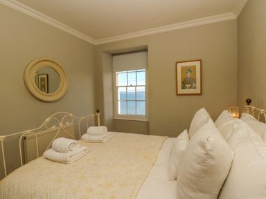 A bedroom with a bed and window at Zenobia in New Quay