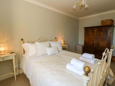 A bedroom with a bed, pillows, and towels at Zenobia in New Quay