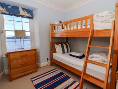 A bedroom with a bunk bed and a dresser at Zenobia in New Quay