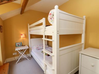 A bedroom with a bunk bed and a lamp at Zenobia in New Quay