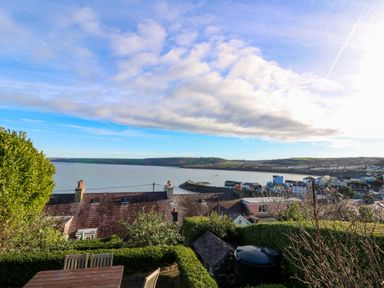 A view of the ocean and houses from a terrace at Zenobia in New Quay