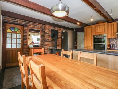 A kitchen with a dining table and chairs at Neuadd Wen in Gaerwen