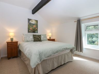 A bedroom with a bed and nightstands at Neuadd Wen in Gaerwen