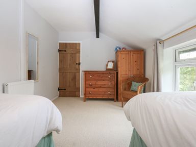 A bedroom with a bed, mirror, and dresser at Neuadd Wen in Gaerwen