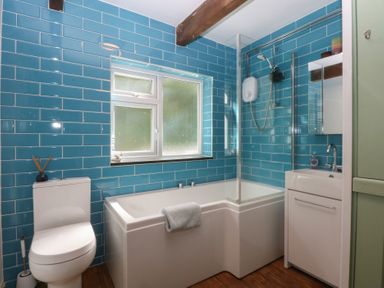 A bathroom with a bathtub and shower at Neuadd Wen in Gaerwen