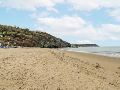 A beach with sand and water at Awel Deg, Tresaith
