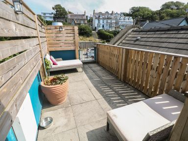 An outdoor area with seating and a planter at Awel Deg, Tresaith