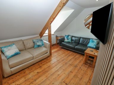 A living room with sofas and a coffee table at Awel Deg, Tresaith