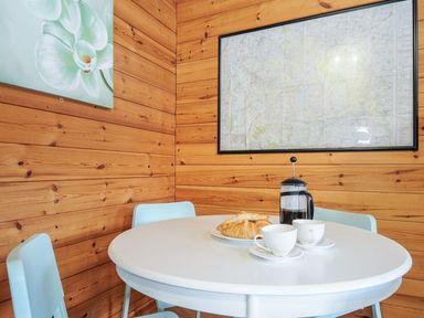A dining room with a round table and chairs at Trevano in St Breward