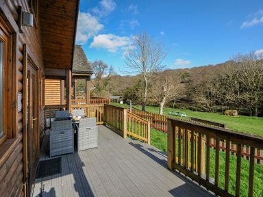 An outdoor area with a deck, table and chairs at Trebah in St Breward