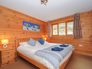 A bedroom with a bed and wooden furniture at Trebah in St Breward