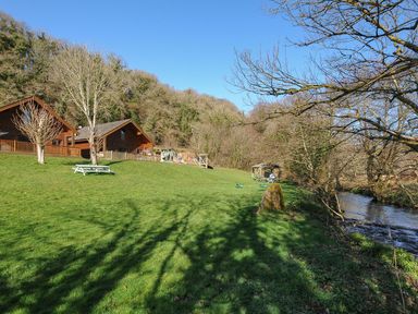 A view of lodges and playground on a grassy area at Trebah in St Breward