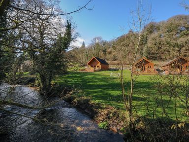 A view of cabins near a river at Trebah in St Breward