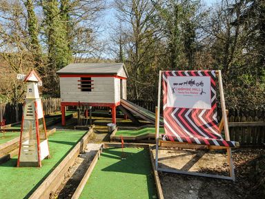 A playground with a slide and mini golf course at Coombe Mill in Cornwall